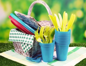 Bright plastic tableware on grass close-up