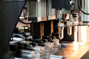 Automatic PET/ Plastic bottle blow moulding machine working in factory.